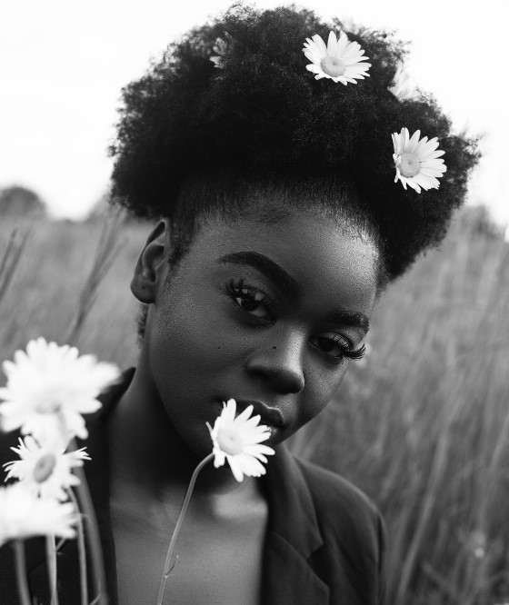 Grayscale photo of woman with daisies in her hair